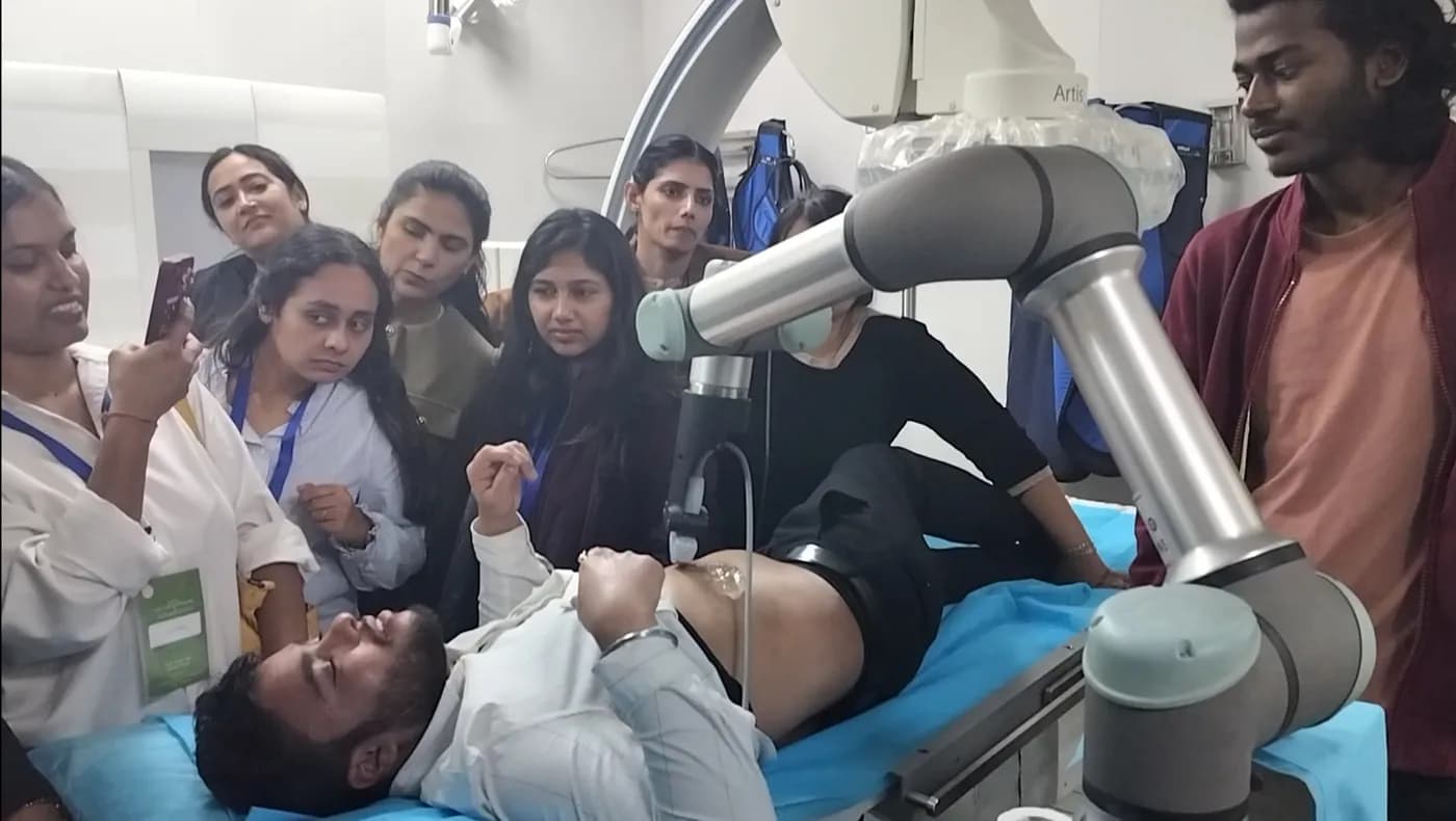 Students watching the robotic arm scan a volunteer at AIIMS New Delhi
