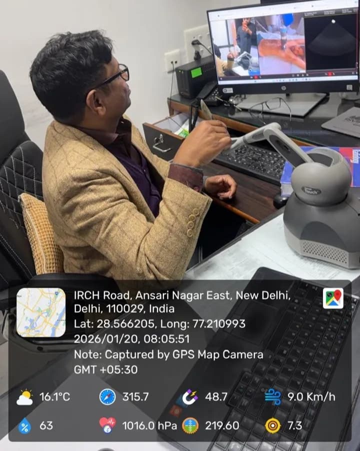A doctor at a desk guiding a haptic controller while watching the live scan on screen